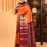 Vibrant Orange With Zari Checks And Purple Border On Kanchipuram Silk Saree