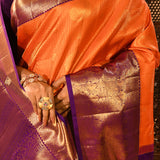 Vibrant Orange With Zari Checks And Purple Border On Kanchipuram Silk Saree