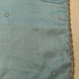 Dusty Blue Organza Saree With Hand Embroidered Floral Booti And Antique Gold Leaf Border
